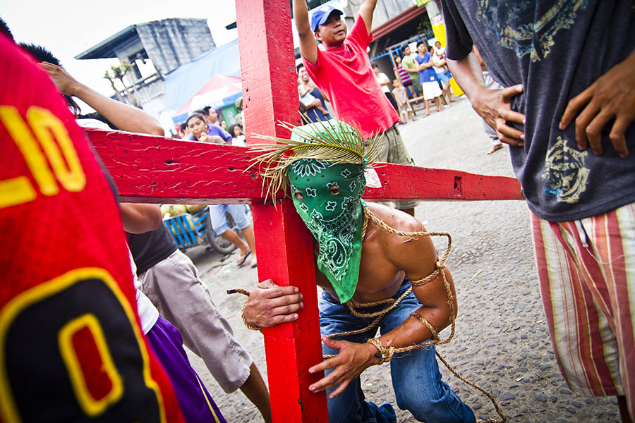 A celebrant lifts a crucufix during processions in Angeles, The Philippines.