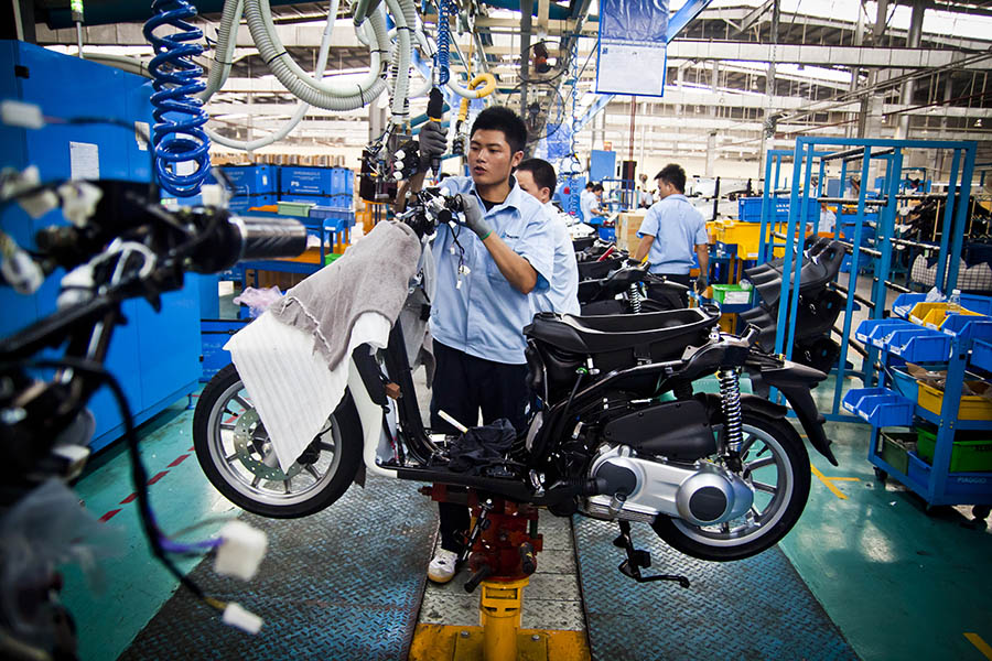 A worker assembling a scooter on the Piaggio production line in Vietnam