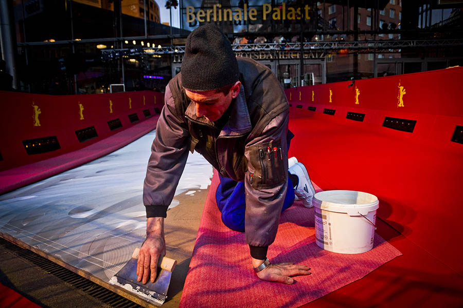 A worker spreading glue for the Berlinale Film Festival red carpet outside the Potsdamer Platz Theatre in Berlin, Germany.