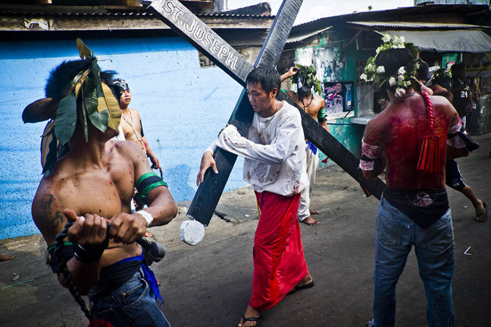 Devotee carrying crucifix in street