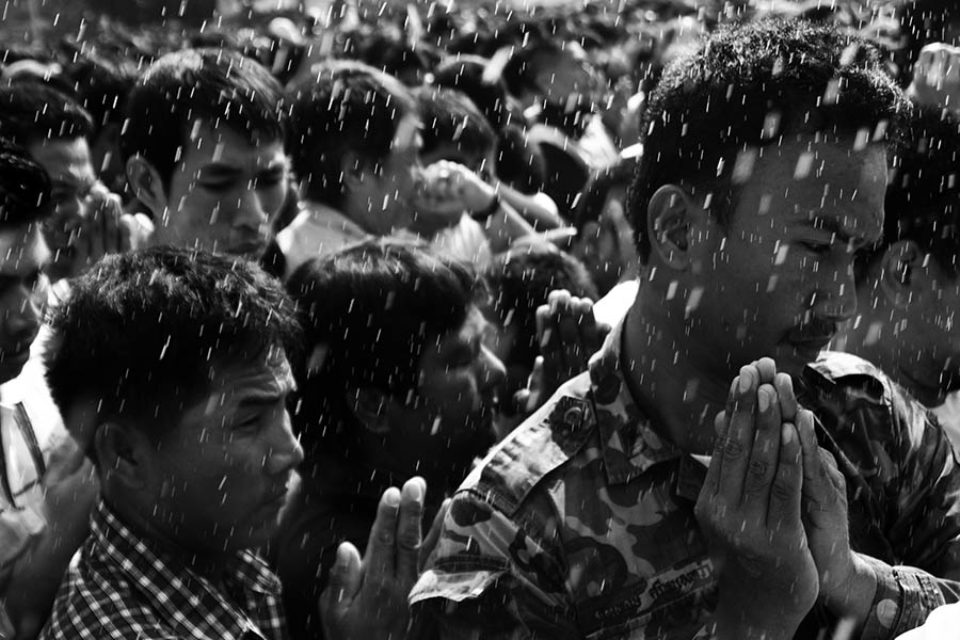 Celebrants praying as they're blessed with water