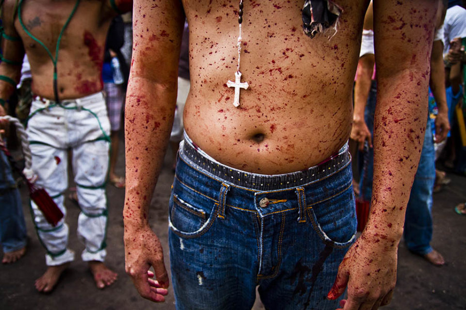 Crucifix necklace worn by blood spattered man