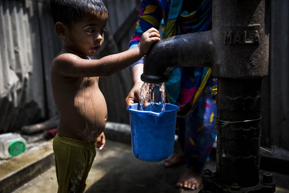 Bangladesh arsenic - Young boy with tubewell