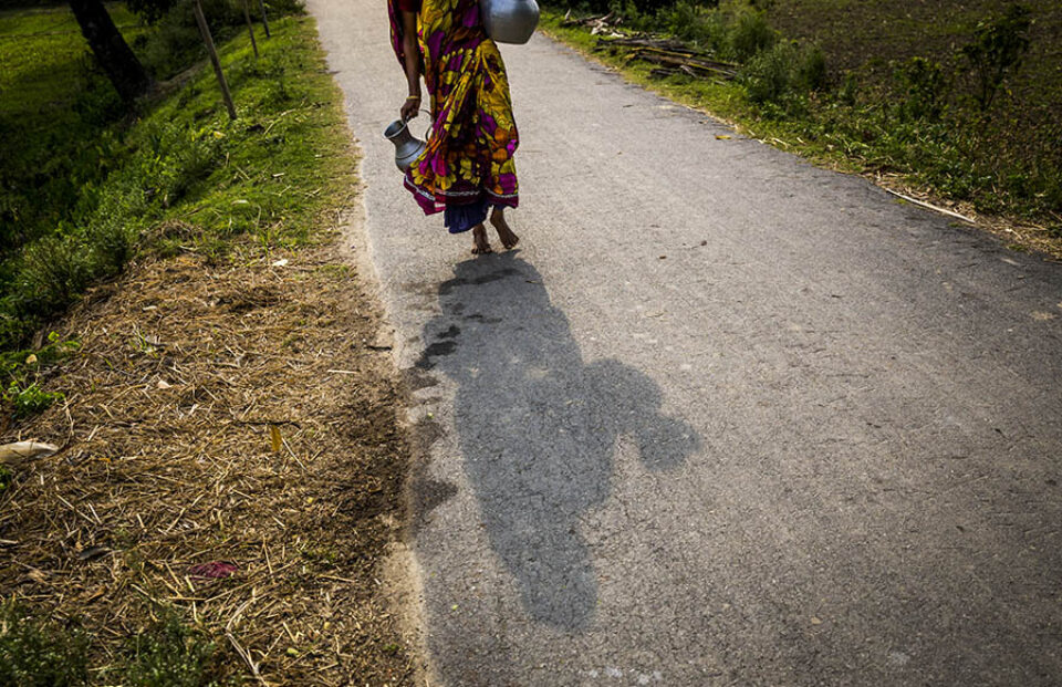 Woman collecting drinking water in jars