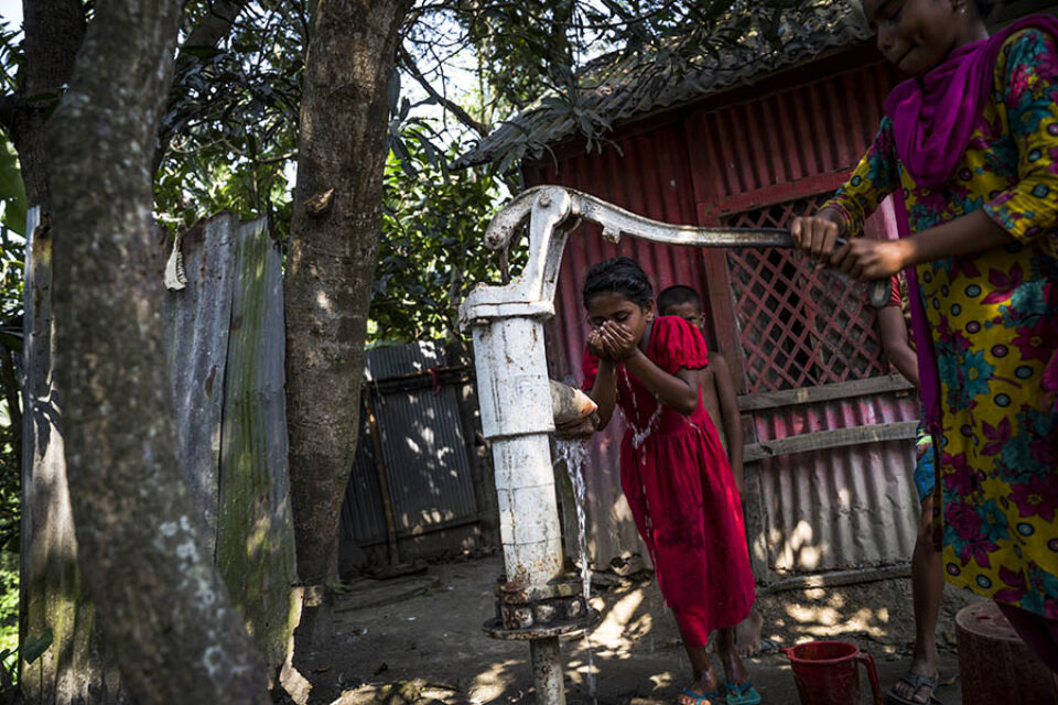 Girl drinking from a village tubewell