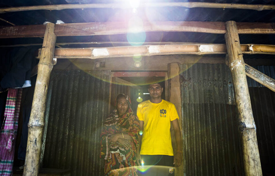 Portrait of mother and son in front of their house