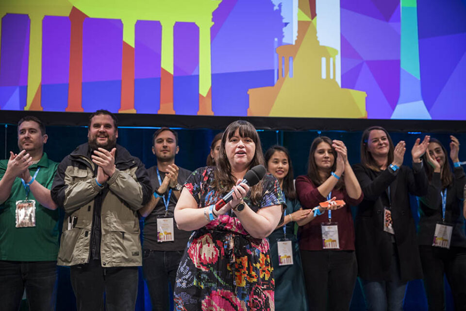 Employees applauding delegates onstage