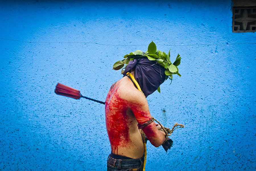 Masked celebrant whips his blood covered back