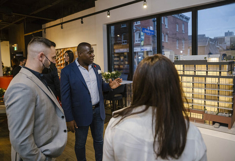 Broker shows clients condo scale model