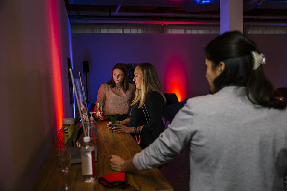 Women look at computer during event