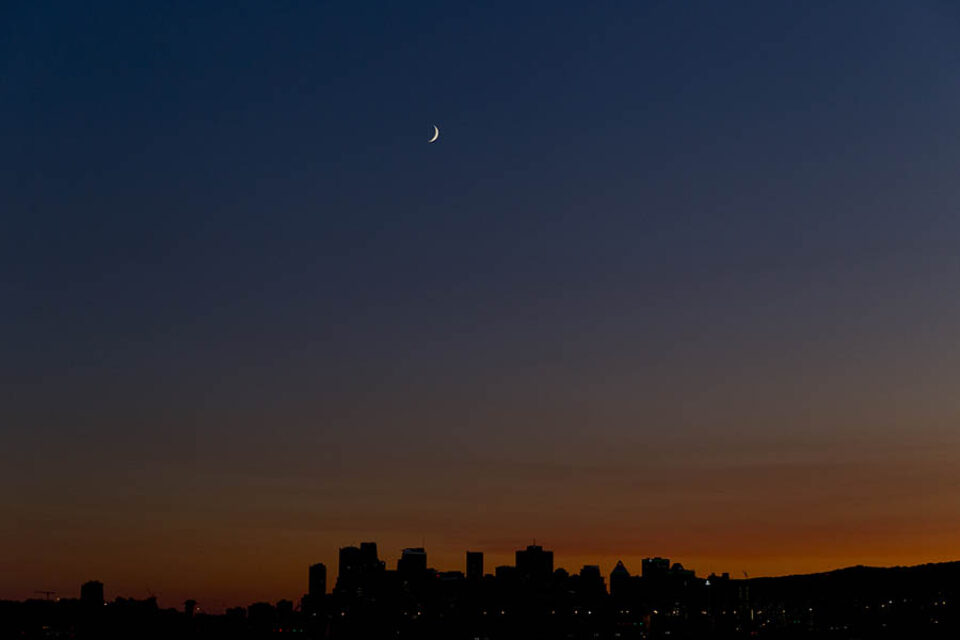 Crescent moon over Montreal skyline