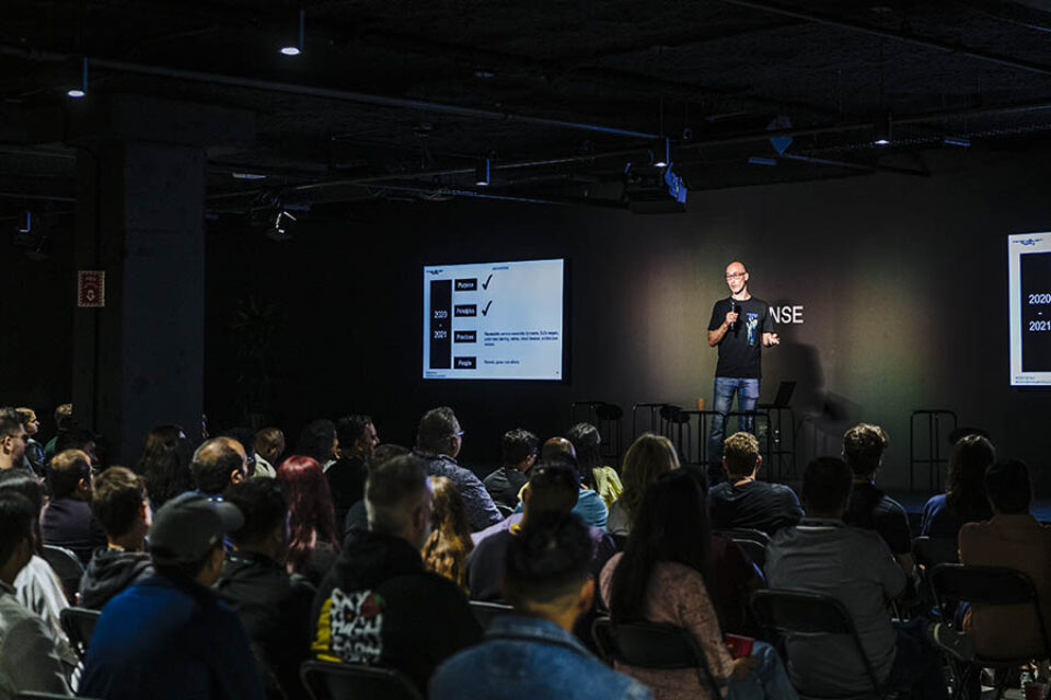 Presenter onstage with audience watching