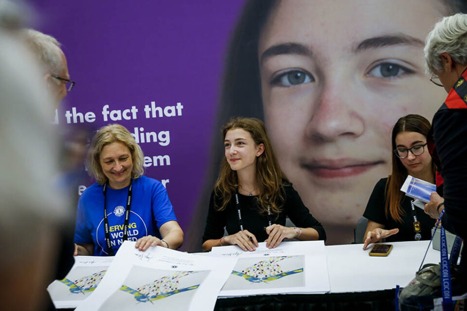 Young artist autographing her artwork