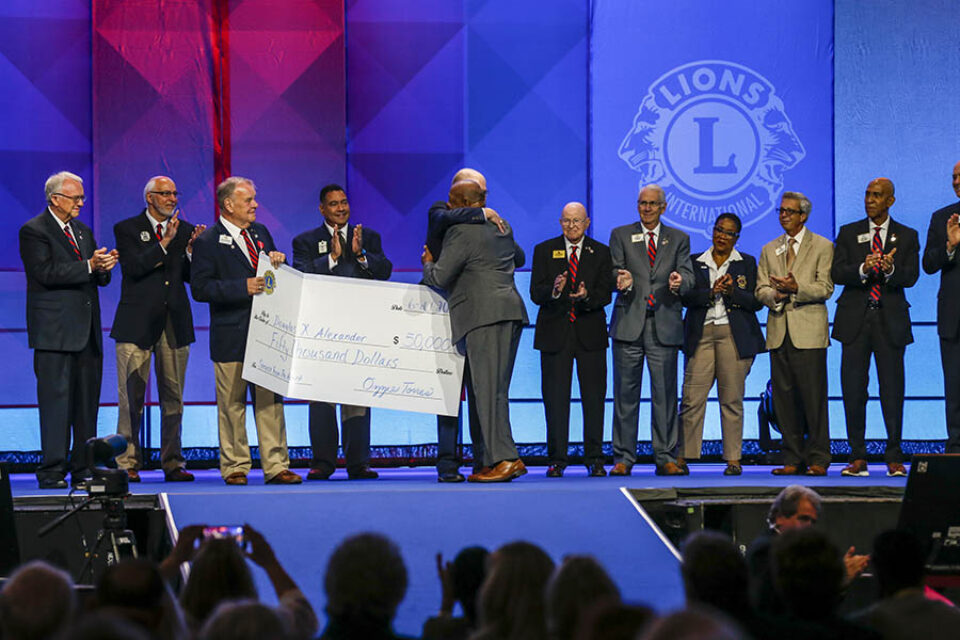 Outgoing Lions Club president presented with cheque onstage