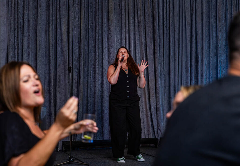 Women singing karaoke at corporate event