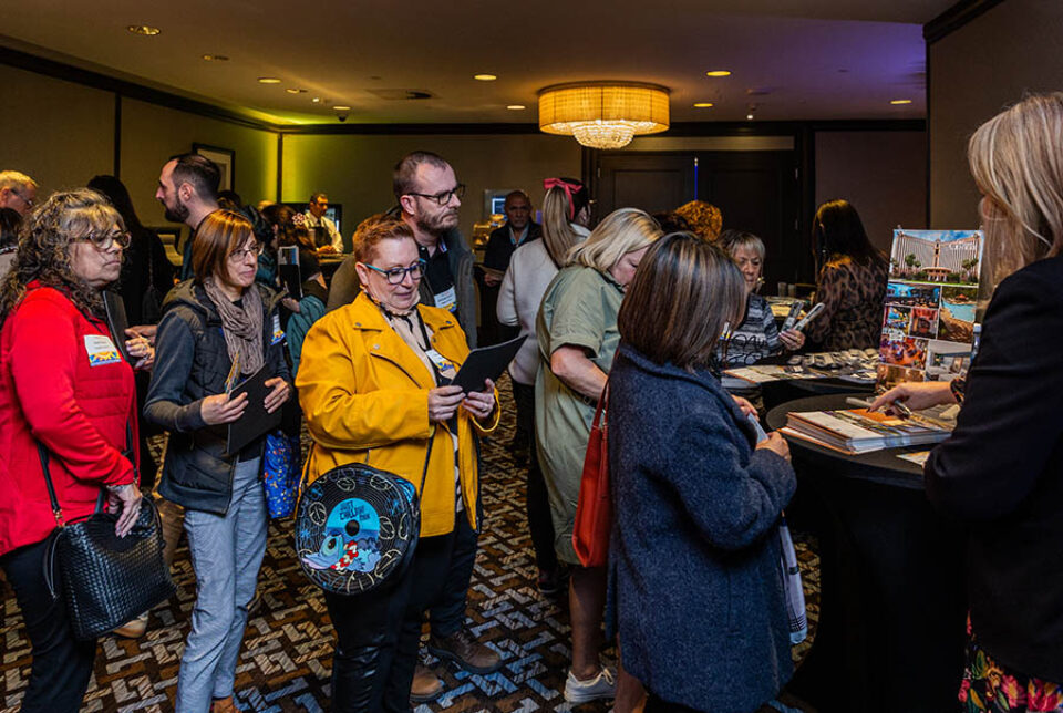 Event delegates queue for travel brochures and information